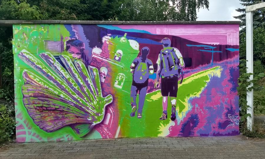Graffiti-Wand mit Muschel und Wanderern