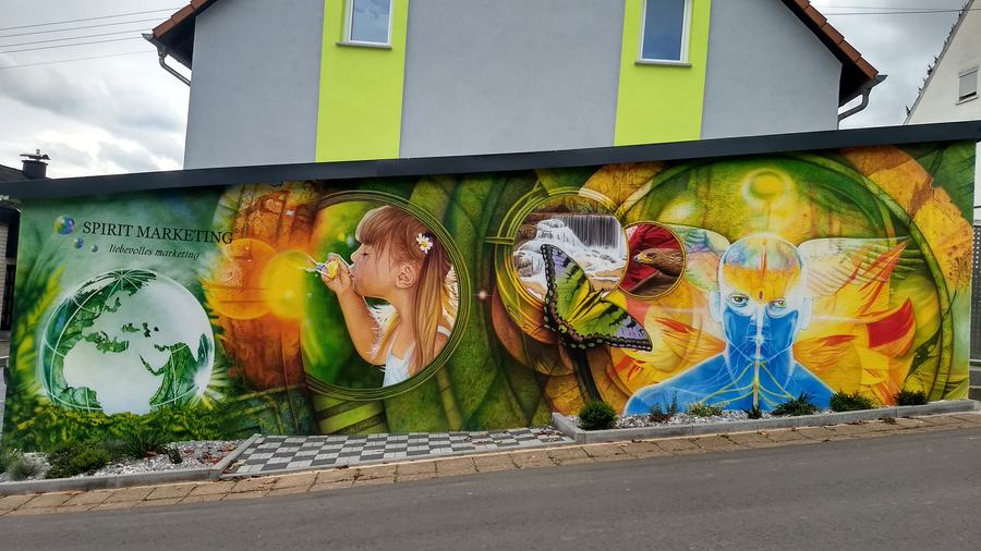 Fassade in Eiweiler: die fertige Längsseite mit Weltkugel, Mädchen und Schmetterlingen