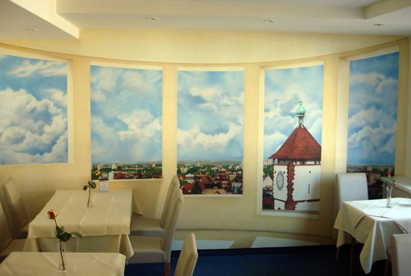 Illusionsmalerei im City-Hotel Freiburg: gemalte Fenster mit Blick über Freiburg