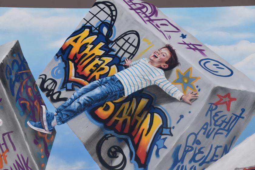 Junge liegt auf einem Graffiti-Quader